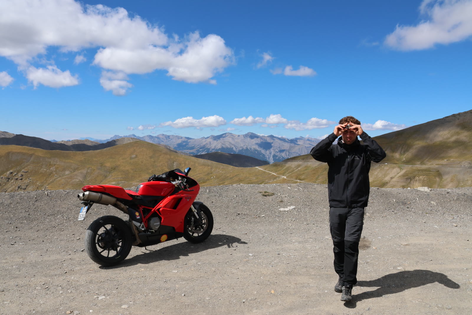 Moto sportive rouge au sommet d'un col alpin